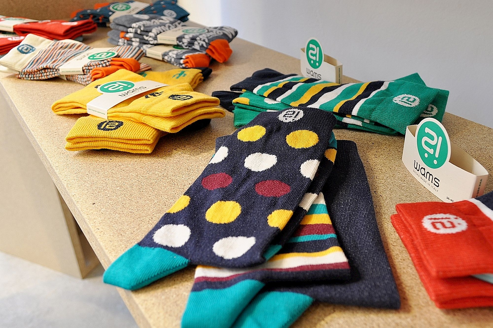Bunte Socken in verschiedenen Mustern auf einem Regal in einem Geschäft ausgestellt.
