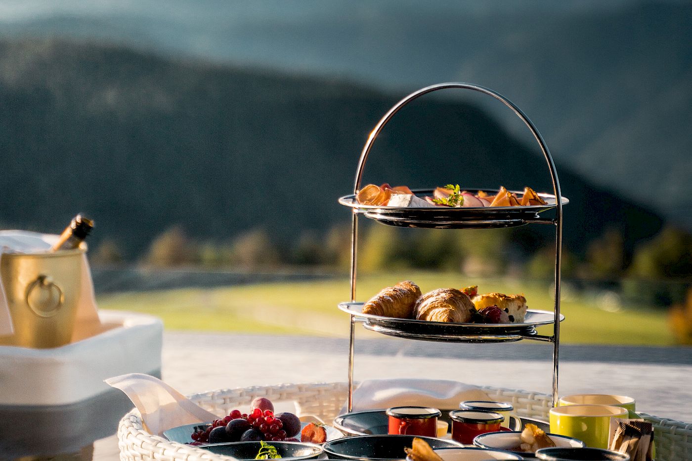 Floating breakfast tray with pastries and fruit in an infinity pool with mountain view in the background.